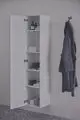 Weißer, offener Wandschrank mit mehreren Regalen, gefüllt mit Handtüchern und Pflegeprodukten. Neben einem Handtuchhalter hängt ein grauer Bademantel. Ideal Standard.